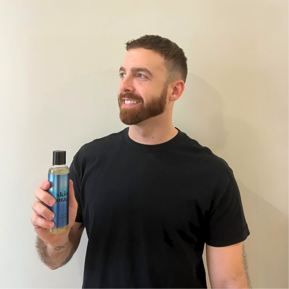Louie Lopez, founder of skin magic, holding the 10% Glycolic Exfoliating Treatment Tonic